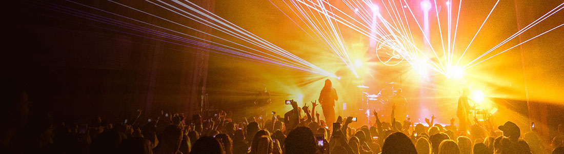 Guest Services banner featuring an energetic concert scene with colorful laser lights and a cheering crowd.